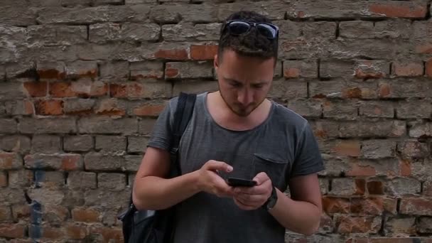 El turista hace una selfie delante de una pared de ladrillo — Vídeo de stock