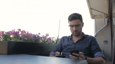Adam bir kafede iki telefon ile çalışır