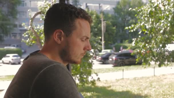 Smutný muž kouří na terase za slunečného dne — Stock video