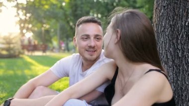 Adam bir şaka bir ağacın altında bir parkta bir kız söylüyor