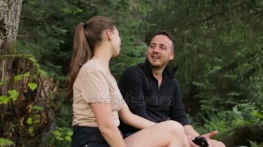 Genç bir çift turist taşları üzerine bir ağacın altında istirahat