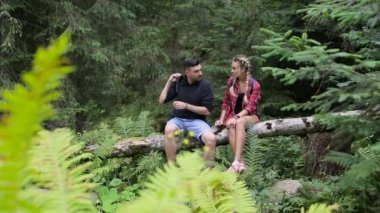 Bir kaç turist dinlenmek düşmüş bir ağaç üzerinde oturan ormanda