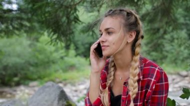 Çok güzel bir genç kız ormanın içinde telefonla konuşuyor