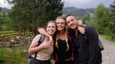 Dağlarda fotoğraf makinesinde poz turist neşeli şirket