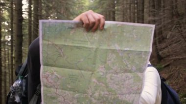 İki hatun ve bir adam bir harita ve orman kamera seyir kullanın