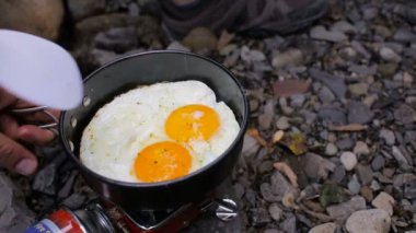 Mens eller bir Nehri yakınında kamp bir soba üzerinde kamp içinde bir tavada kızarmış yumurta ilave edin