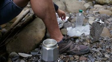 Bir turist adam içine nehir kıyısında bir kamp alanına bir kahve makinesi kahve dökülen