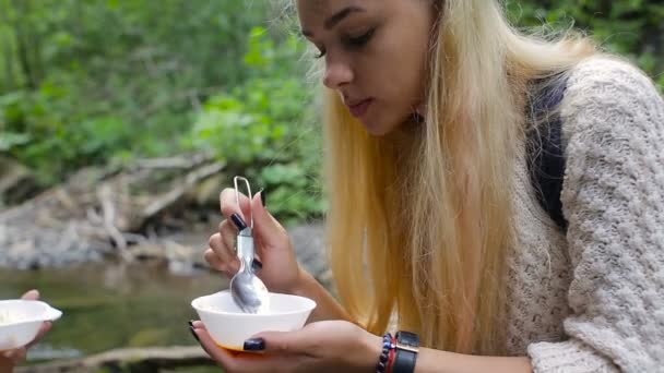 Девушки едят яйца в лагере на берегу реки — стоковое видео