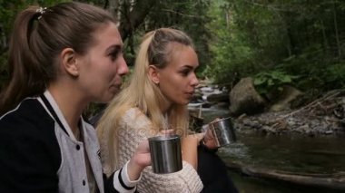 Kadın gezginler bir dere kamp içinde kahve içmek
