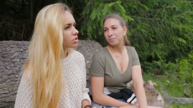 Kızlar büyük bir oturum açma ormanın kenarında oturan konuşuyorsun