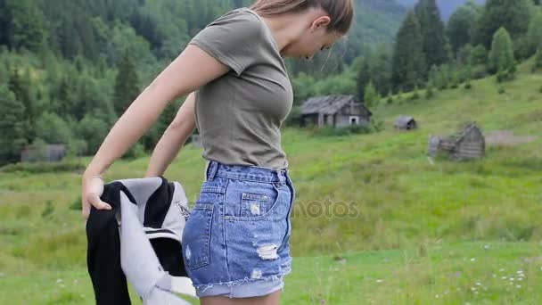 Hermosa chica en un fondo de bosques y pueblos de montaña — Vídeos de Stock