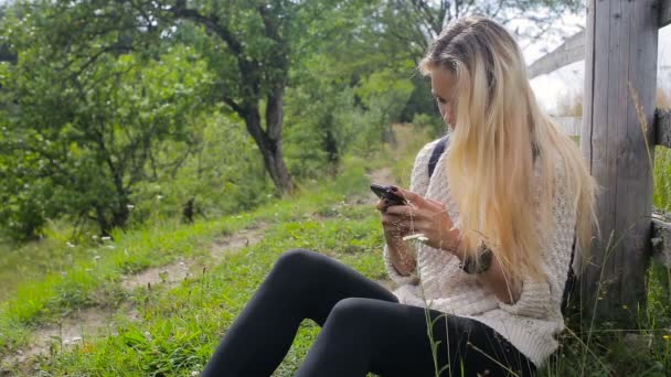 Vrouw kijken naar mobiele telefoon op bergweg — Stockvideo