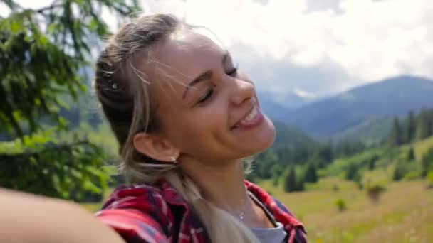 Очень красивая девушка делает селфи в горах — стоковое видео