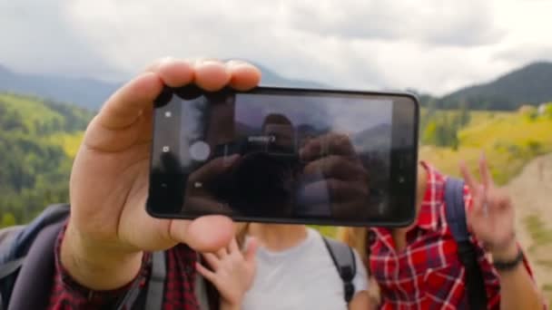 Amigos toman fotos juntos en la tarde en las montañas — Vídeo de stock