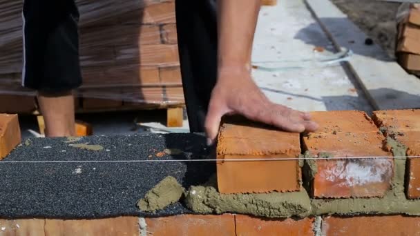 El trabajo pone ladrillos en un sitio de construcción al aire libre — Vídeos de Stock