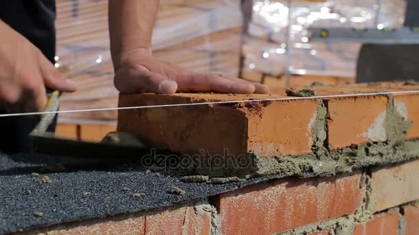 O trabalho coloca tijolos em um canteiro de obras ao ar livre — Vídeo de Stock