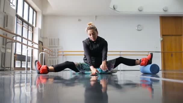 Bailarina se calienta antes de entrenar en una gran sala de ballet — Vídeos de Stock