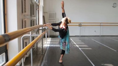 Profesyonel balerin, bir bale barının yanında pratik yapıyor.