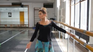 Profesyonel balerin, bir bale barının yanında pratik yapıyor.