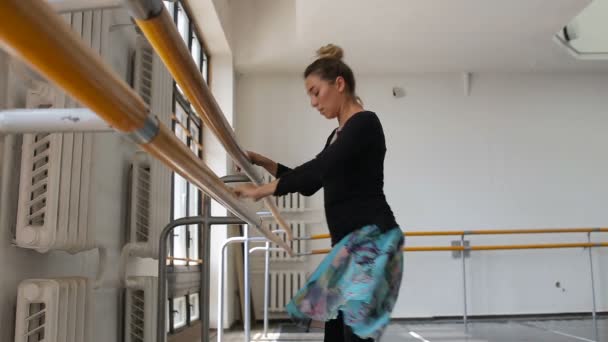 Bailarina de ballet profesional practicando cerca de un bar de ballet — Vídeo de stock