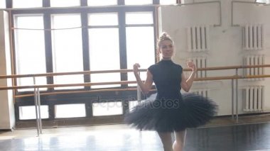 Bir balerin dans büyük eğitim salonunda dönüyor