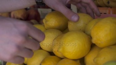 Genç adam ellerini limon meyve Pazar seçimi görünümünü kapat