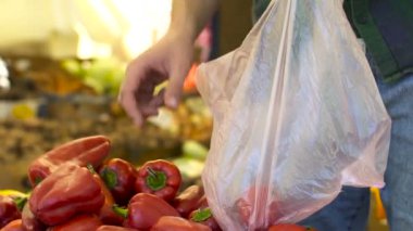 Genç adam görünümü kadar yakın biber meyve piyasada satın alır.