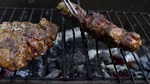 The chef turns the steak with a fork on a barbecue grill, slow motion — Stock Video