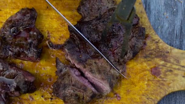 De kok snijdt de afgewerkte steak op een houten bord. Slow motion schieten — Stockvideo