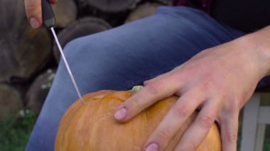 Adam bir kabak Jack-o-fener bahçede bir ağaç kütüğü üzerinden açmaktadır