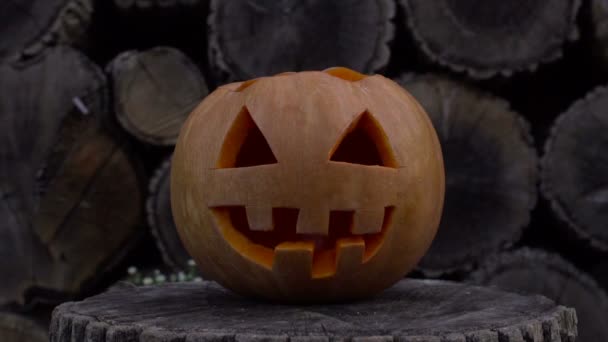 Jack-o-lantern med eld inuti flimrar liggande på en stubbe — Stockvideo