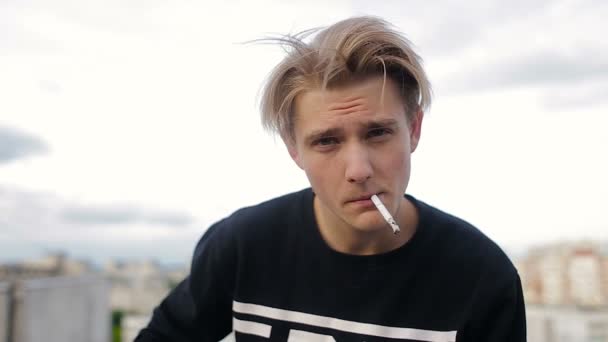 पोर्ट्रेट सिगरेट के साथ छत पर शांत युवा आदमी — स्टॉक वीडियो