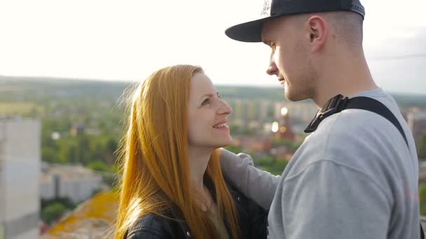 Щаслива молода красива стильна пара дарує прихильність кожному другу на даху будинку — стокове відео