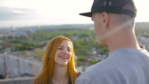 Happy young beautiful stylish couple giving affection to each friend on the roof of the house — Stock Video