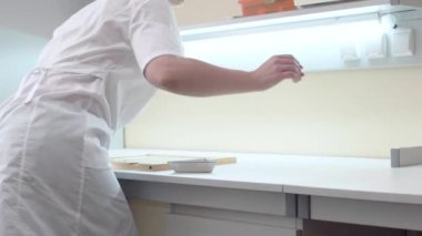 Asistan laboratuvarda tohum test etmek için masa başında oturur.