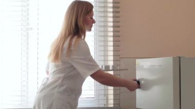 Laboratuar asistanı tohum kurutucuya koyar.