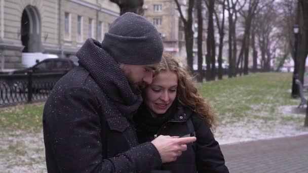 Mladý nádherný pár používá telefon na podzim park — Stock video