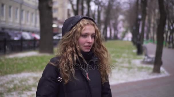 Young beautiful girl jumping in the park to keep warm — Stock Video