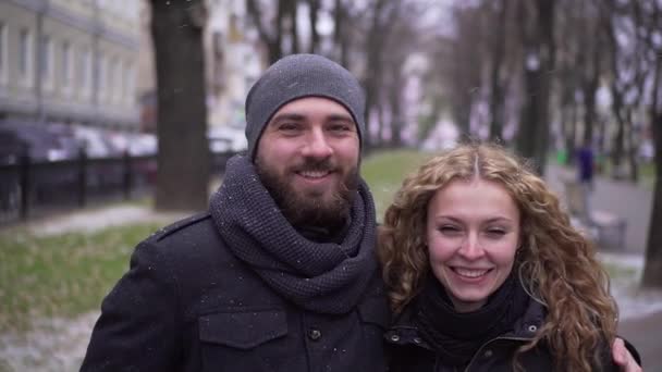 Skäggiga killen och curly flicka titta på kameran och smile i Vinterparken — Stockvideo