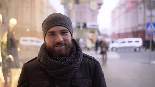 Πορτρέτο του ένα χαρούμενο νεαρός άνδρας σε έναν δρόμο τον χειμώνα στην πόλη — Αρχείο Βίντεο