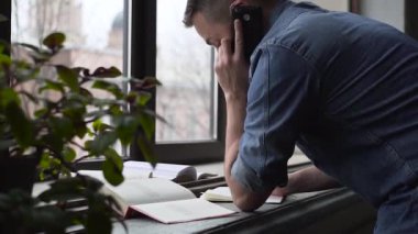Pan gencin pencerenin yakınındaki telefon durarak öğrenmede yardım alır