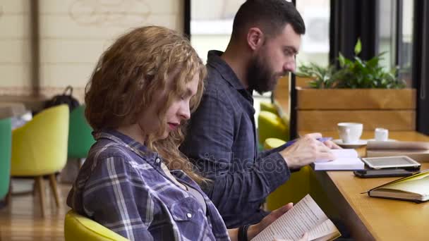 Mouvement lent des étudiants se préparent ensemble pour les examens assis dans un café — Video