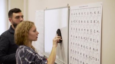 Orta genç adam ve bir kadın çalışma hiyeroglif sınıfta birlikte vurdu