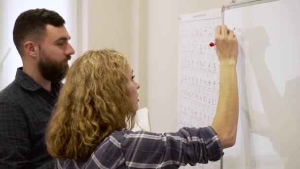 Medium shot of young teacher teaches a young woman the Chinese alphabet — Stock Video