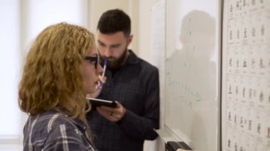 Yorgun kadın orta çekim veri işaretleyici beyaz tahta üzerinde yazıyor.