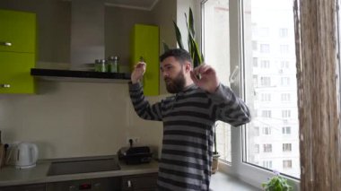 Genç adam kollarını mutfak penceresinde yanında uzanan orta vurdu