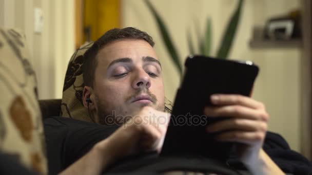 Střední záběr muže v tabletu na posteli a usínání — Stock video