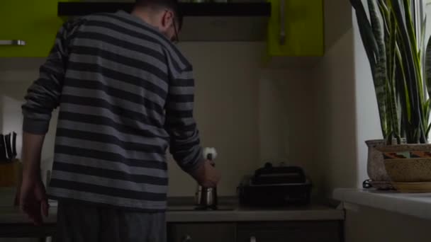 Plan moyen de l'homme met une cafetière geyser sur une cuisinière — Video