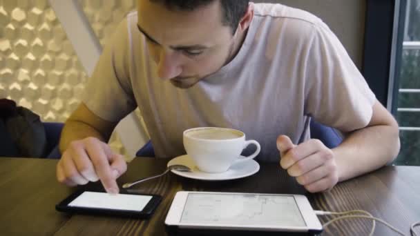 Jovem empresário olha para cursos Criptomoeda em um café — Vídeo de Stock