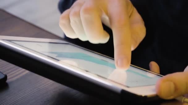 Крупным планом человек изучает курс криптовалюты на планшете в кафе — стоковое видео